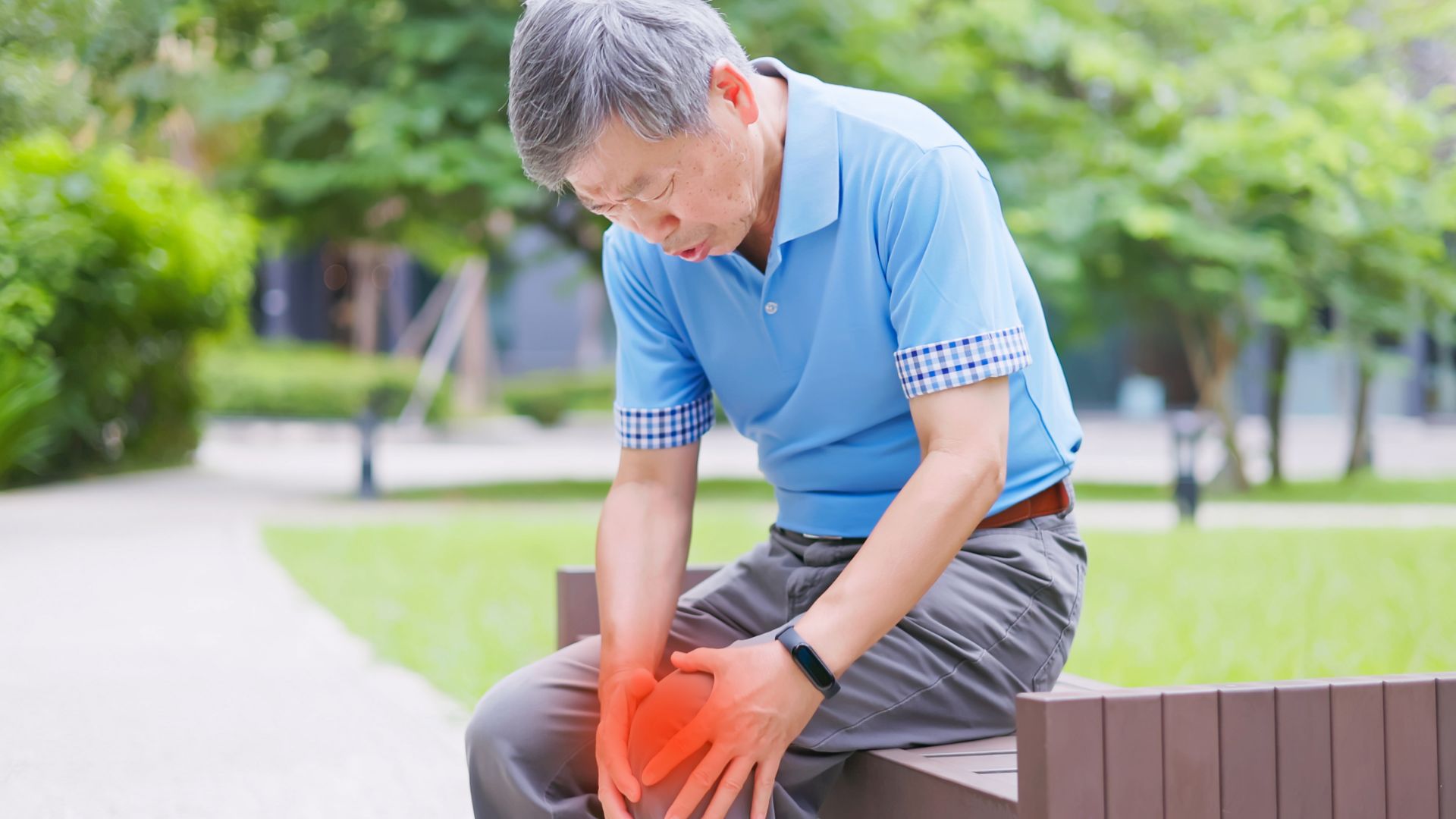 An old man sitting at garden with knee pain